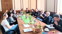 Stół otoczony przez ludzi, którzy cieszą się napojami i wspólną rozmową