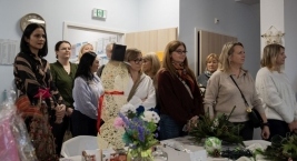 Uczestnicy stoją przy pracach plastycznych