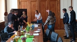 Ludzie stoją przy stole, angażując się w rozmowę