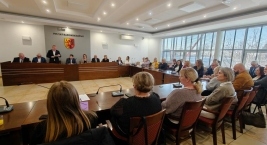 Duża grupa osób siedzących przy długim stole podczas spotkania