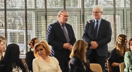 Duża grupa osób siedzących przy długim stole podczas spotkania